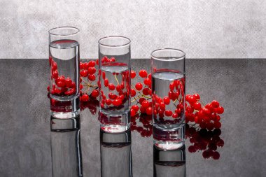 Hayat üç cam bardak ve kırmızı viburnum çileğiyle dolu