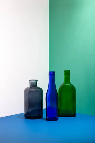 Stillleben Mit Glasflaschen Auf Farbigem Hintergrund — Stockfoto