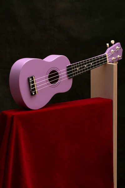 Four String Ukulele Guitar Red Cloth Shelf — Stock Photo, Image