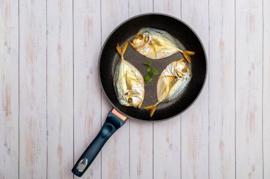 Tütsülenmiş deniz balığı kızartma tavasında bencilce yakın plan.