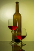 Zátiší se skleněnou lahví a sklenicemi na víno