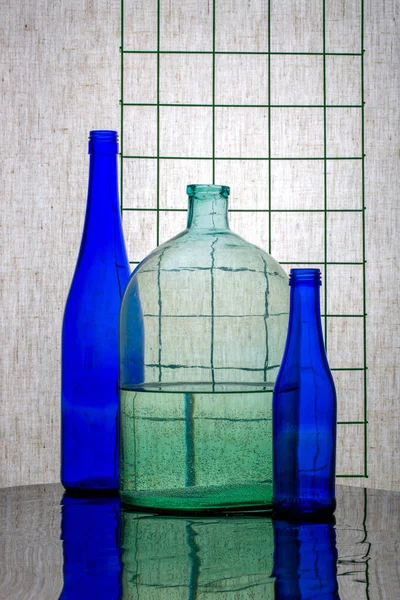 Stillleben Mit Blauen Flaschen Und Einem Glas Mit Wasser — Stockfoto