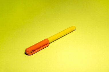 Sarı arka planda turuncu kapaklı sarı dolmakalem