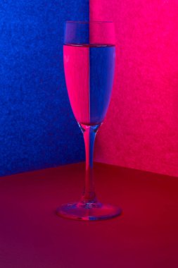 Mavi-kırmızı arka planda bir bardak sıvı ile durgun bir hayat