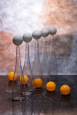 Şeffaf figürlerle, beyaz ve turuncu toplarla dolu