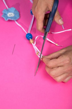 Ustanın kadın elleri, keçeli yünden yapılmış el yapımı bir ürünü birleştirir.