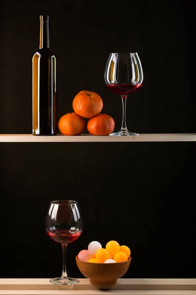 Stillleben Mit Bunten Kugeln Teller Flasche Weingläsern Und Mandarinen — Stockfoto