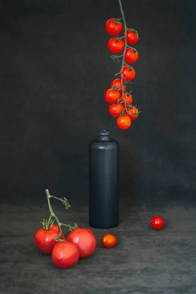 Stillleben Mit Tomaten Auf Einem Zweig Und Einer Schwarzen Flasche — Stockfoto