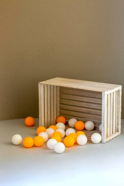 Dökülmüş beyaz ve sarı topları olan tahta kutu.