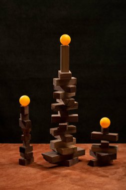 Üzerinde turuncu toplar olan tahta küplerden yapılmış figürler.