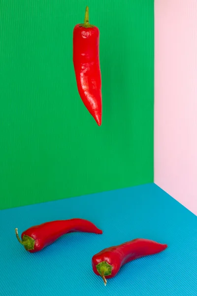 Натюрморт Тремя Красными Перцами Углу Цветном Фоне — стоковое фото