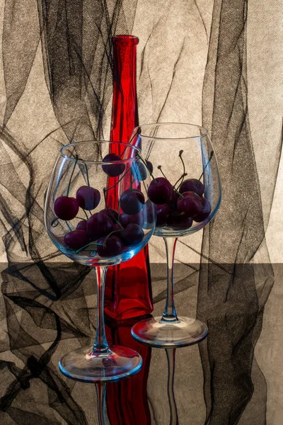 Still Life Red Bottle Cherries Glasses — стоковое фото