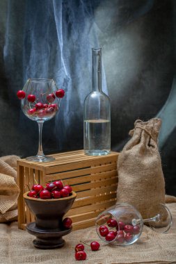 Olgun kirazlarla dolu bir vazo ve bardakta hayat