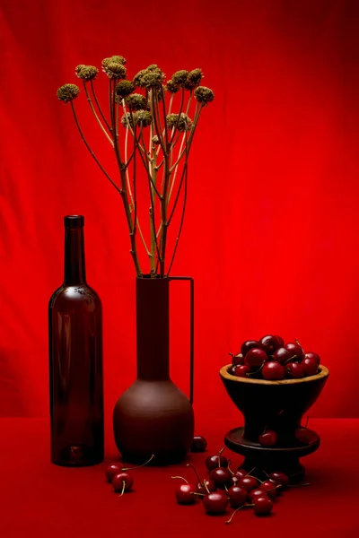 Still Life Cherries Bottle Vase Dried Flowers — Zdjęcie stockowe