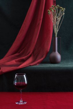 Still life with a dried bouquet of flowers and a glass of wine