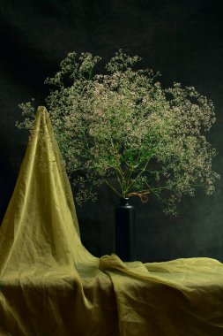 A large bouquet of wild flowers on the table in a glass vase
