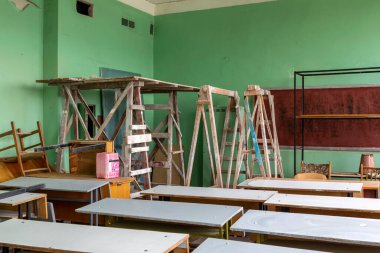 A fragment of the classroom interior with desks and construction equipment for repair