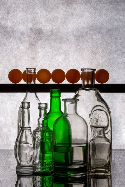 Натюрморт Стеклянными Бутылками Оранжевыми Шариками — стоковое фото