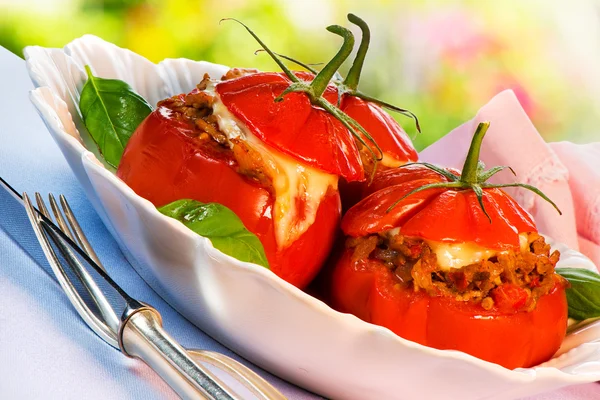 Três tomates recheados em um prato branco — Fotografia de Stock