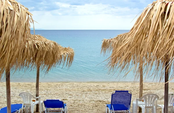 Camas de sol vazias com guarda-chuvas na bela praia — Fotografia de Stock