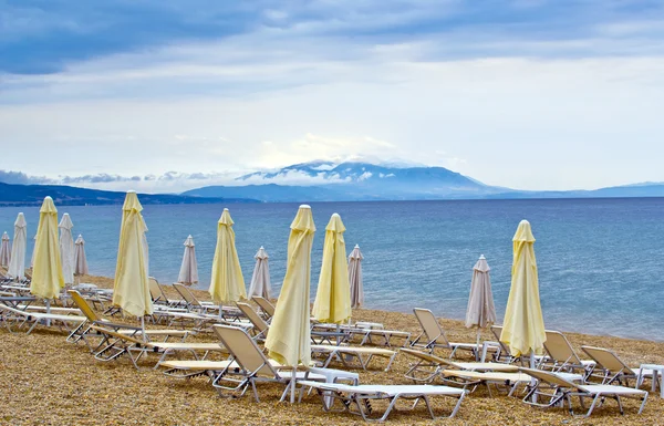 太陽の loungers 曇り日没日の出の風景とビーチの傘 — ストック写真