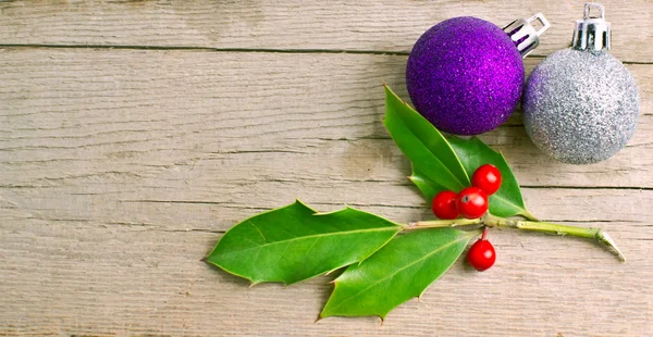 Baga azevinho de Natal com bagas vermelhas em madeira com decoração de bola — Fotografia de Stock