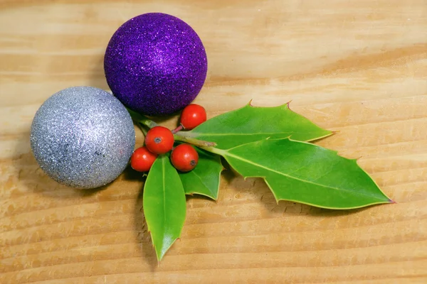 Christmas holly berry s červenými plody na dřevo s míčem dekorace — Stock fotografie