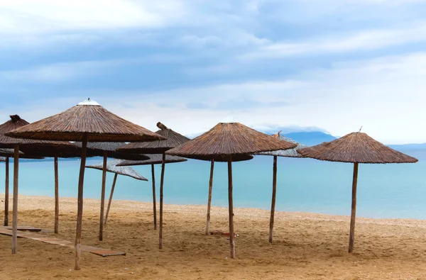 Guarda-chuva de palha na praia com céu azul de manhã férias de verão cena de viagem — Fotografia de Stock