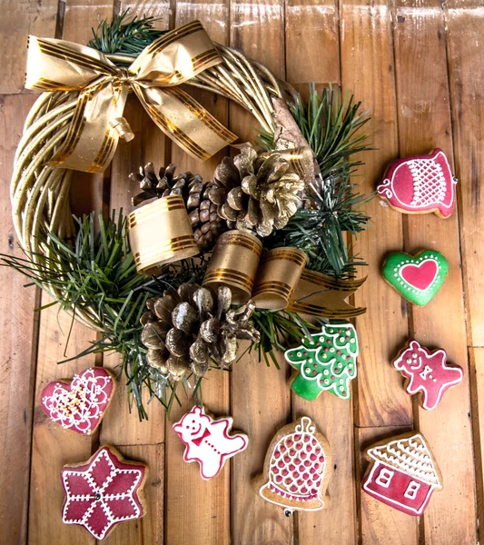 Grinalda de Natal e pão de gengibre na madeira — Fotografia de Stock