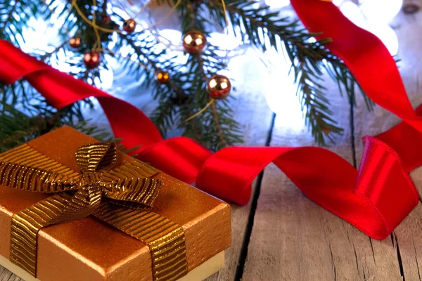 Pudełko z złote wstążki i Bożego Narodzenia ozdoba na drewnianym stole — Zdjęcie stockowe