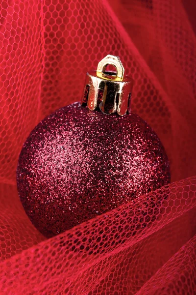 Christmas ball on a red silk cloth — Stock Photo, Image