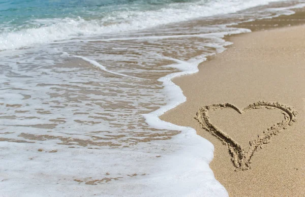 Profilo a forma di cuore sulla spiaggia bagnata sabbia contro l'onda del mare — Foto Stock