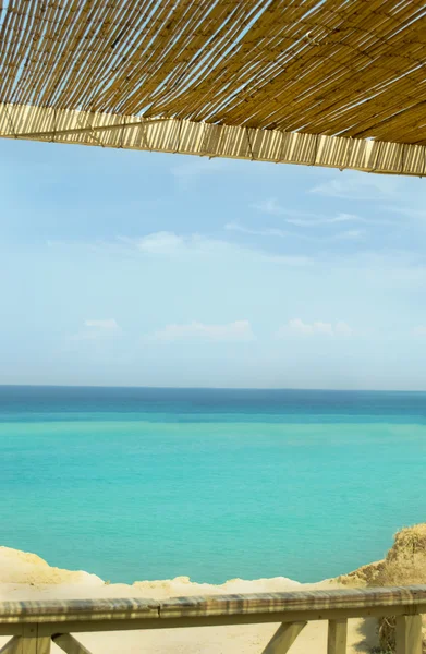 Beach straw parasol umbrella against blue sky — Stock Photo, Image