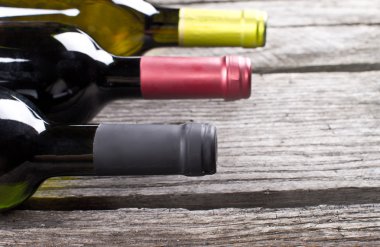 ahşap bir masa üzerinde şarap şişeleri