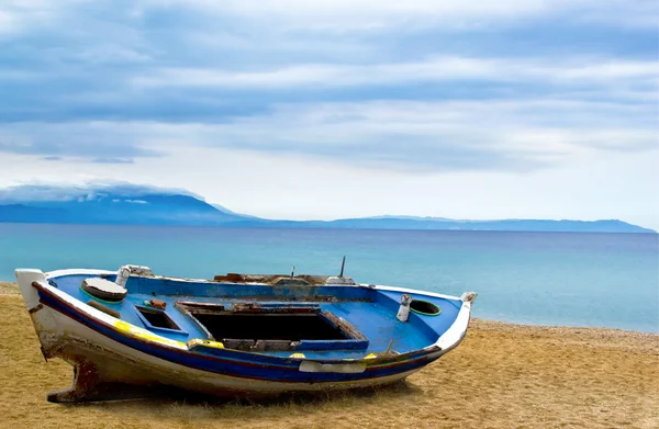 Рыбацкая лодка на пляже песок океана утреннее небо — стоковое фото