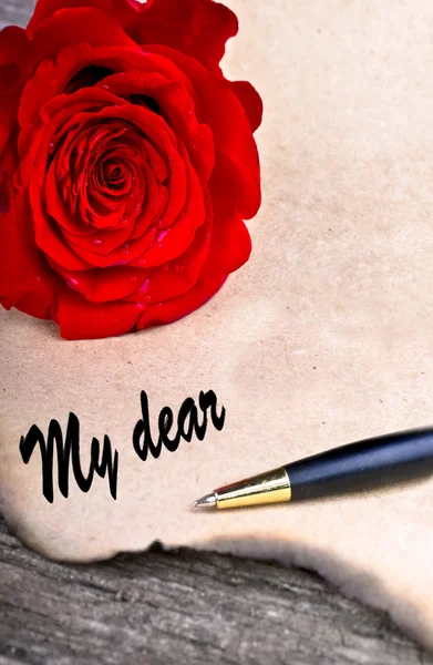 Κόκκινο τριαντάφυλλο σε παλιά έννοια επιστολή woodlove στο ξύλινο τραπέζι — Φωτογραφία Αρχείου
