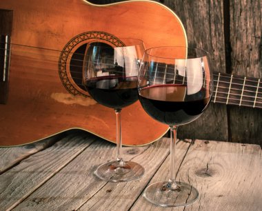Gitar ve şarap bir ahşap masa romantik akşam yemeği arka plan üzerinde
