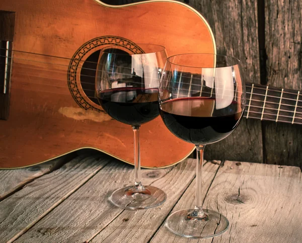 Gitarr och vin på ett träbord romantisk middag bakgrund — Stockfoto