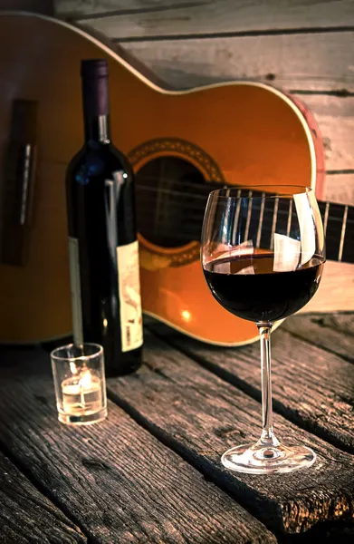 Gitar ve şarap bir ahşap masa romantik akşam yemeği arka plan üzerinde