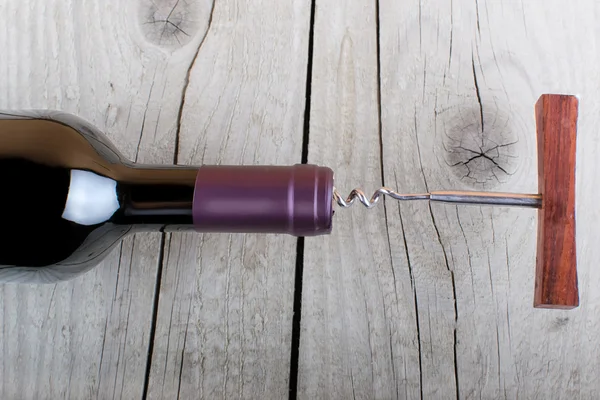 Botella de vino sobre una mesa de madera — Foto de Stock