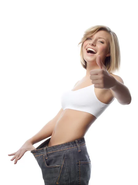 Kobieta pokazuje jej stare ogromne parę dżinsów — Zdjęcie stockowe