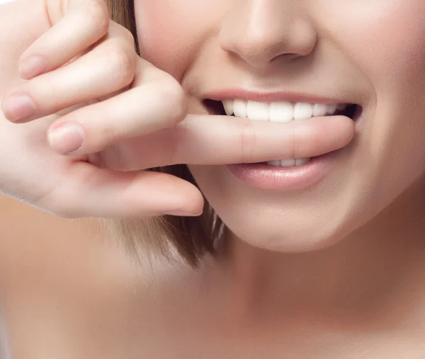 Mujer sonriente se muerde el dedo —  Fotos de Stock