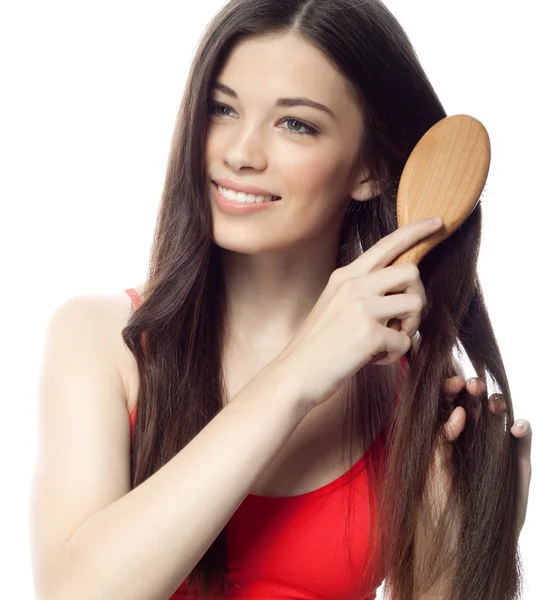 Mulher está escovando seu cabelo longo — Fotografia de Stock