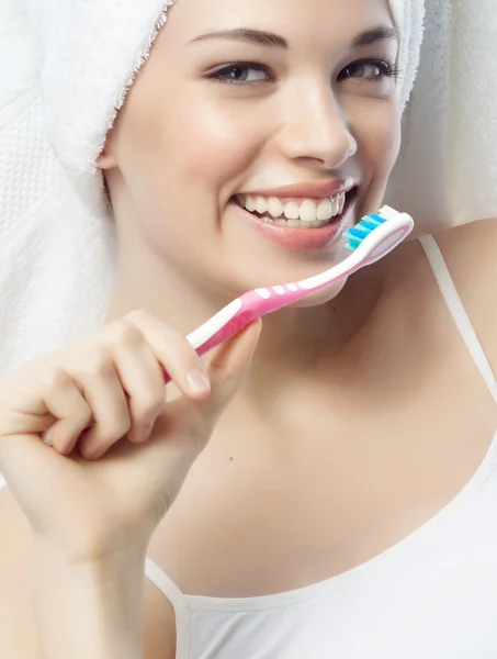 Smiling woman is brushing her teeth — Stock Photo, Image