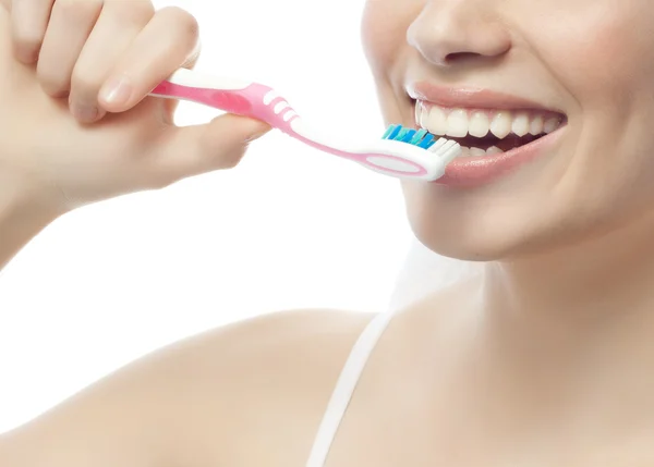 Smiling woman is brushing her teeth — Stock Photo, Image