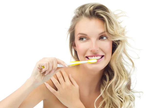 Smiling woman is brushing her teeth — Stock Photo, Image