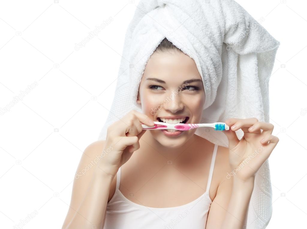 Smiling woman is brushing her teeth