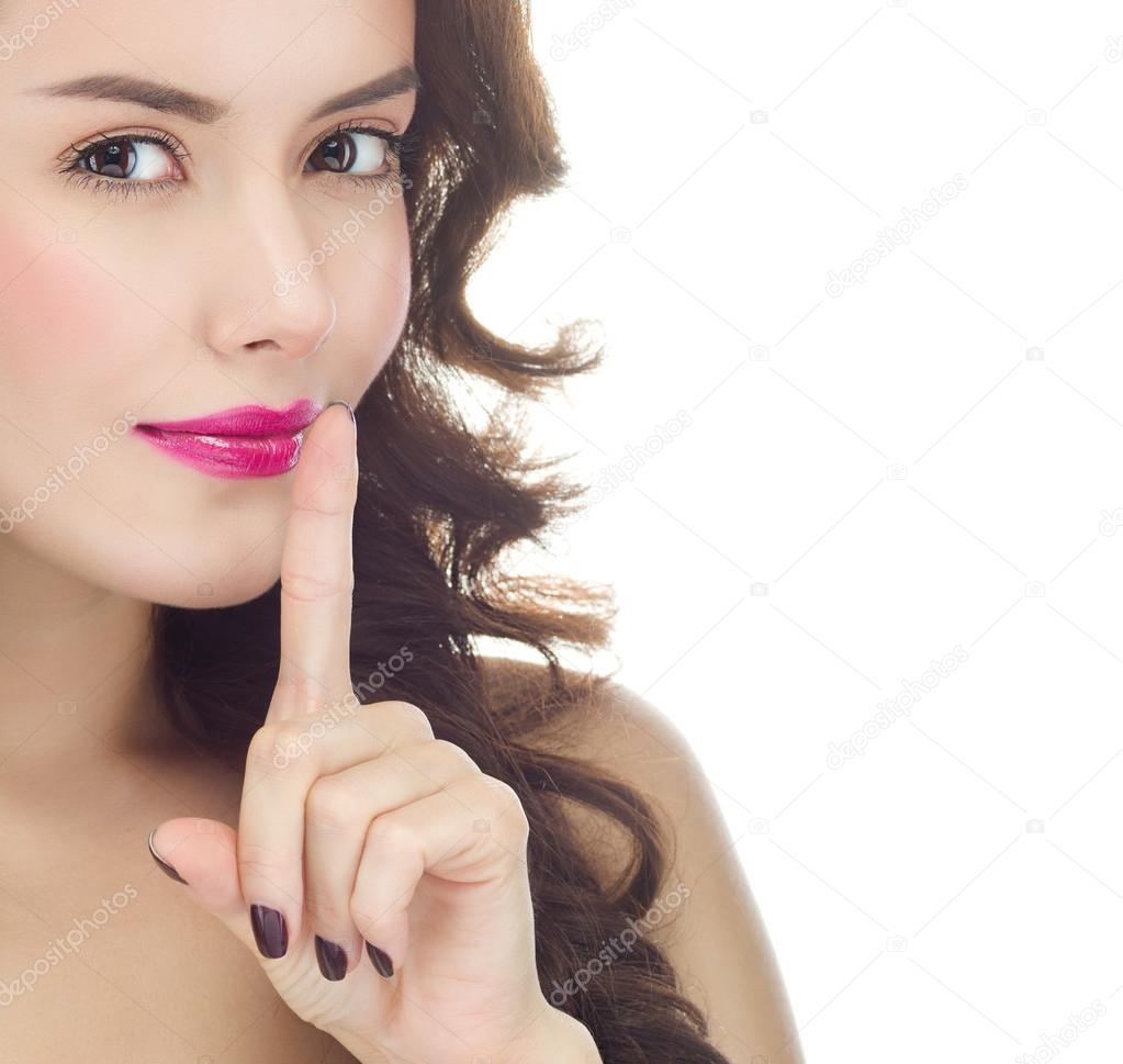 Woman with finger on her lips gesturing shh