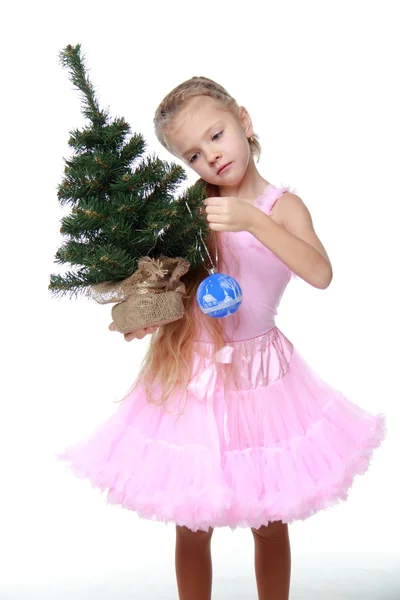 Маленькая девочка украшает елку — стоковое фото