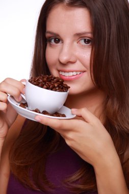 bir fincan kahve çekirdekleri tutan genç kadın